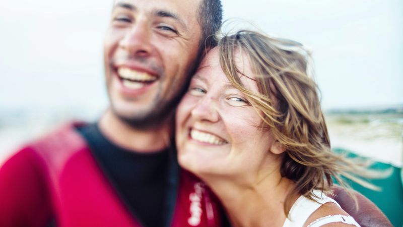 Couple laughing together by the water