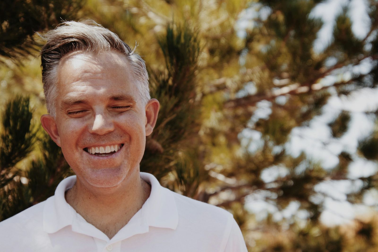 Silver-haired man smiling outdoors
