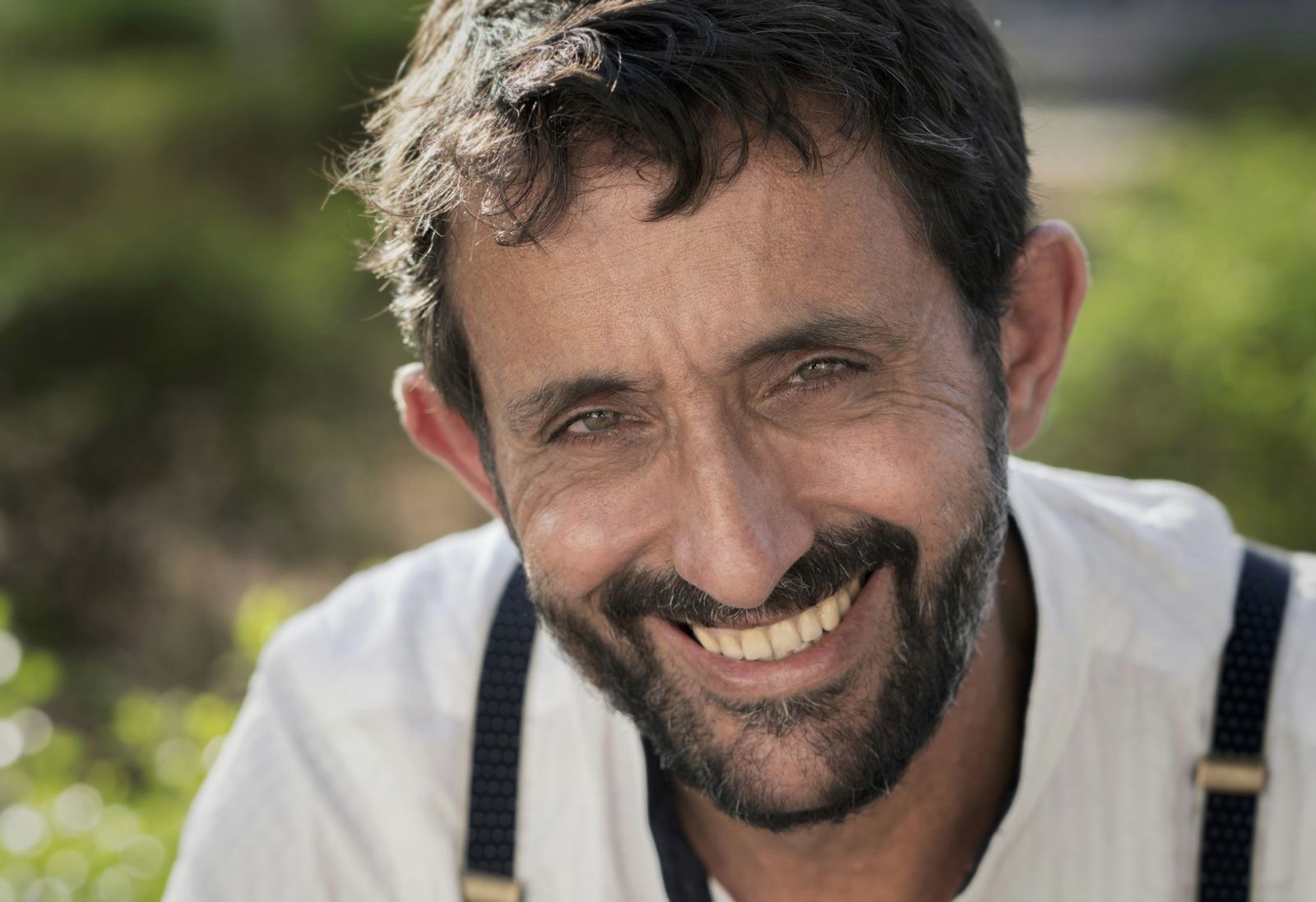 Man with a big, relaxed smile outdoors